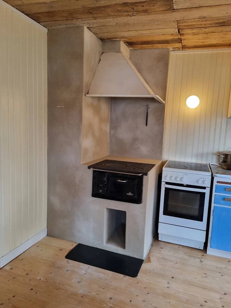 Murad vedspis med spiskåpa i äldre kök